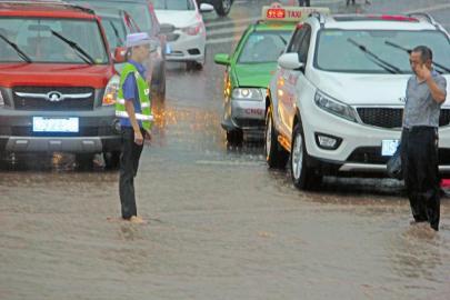 协警暴雨光脚指挥交通,女交警光脚踩水坑