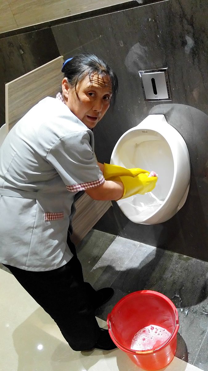 头上滴着汗水手上沾着尿骚味的保洁女工