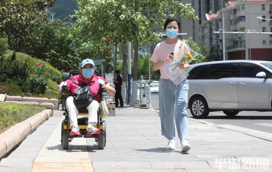 青岛一六旬母亲坐轮椅送考,一位母亲送准考证的感人片段